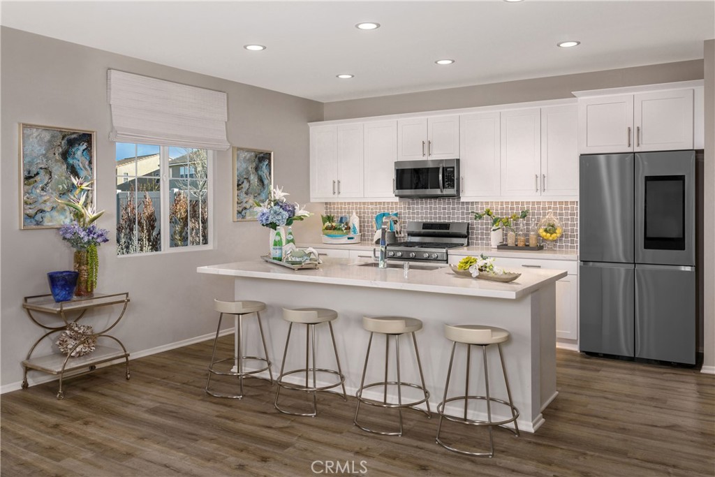9075 Carson Avenue Hesperia, CA 92344 - Photo 2 of 13 a kitchen with stainless steel appliances granite countertop a stove a refrigerator a sink a dining table and chairs