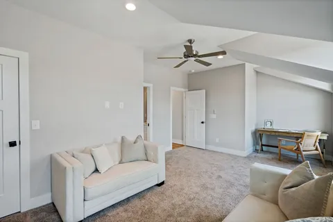 a living room with furniture and a ceiling fan