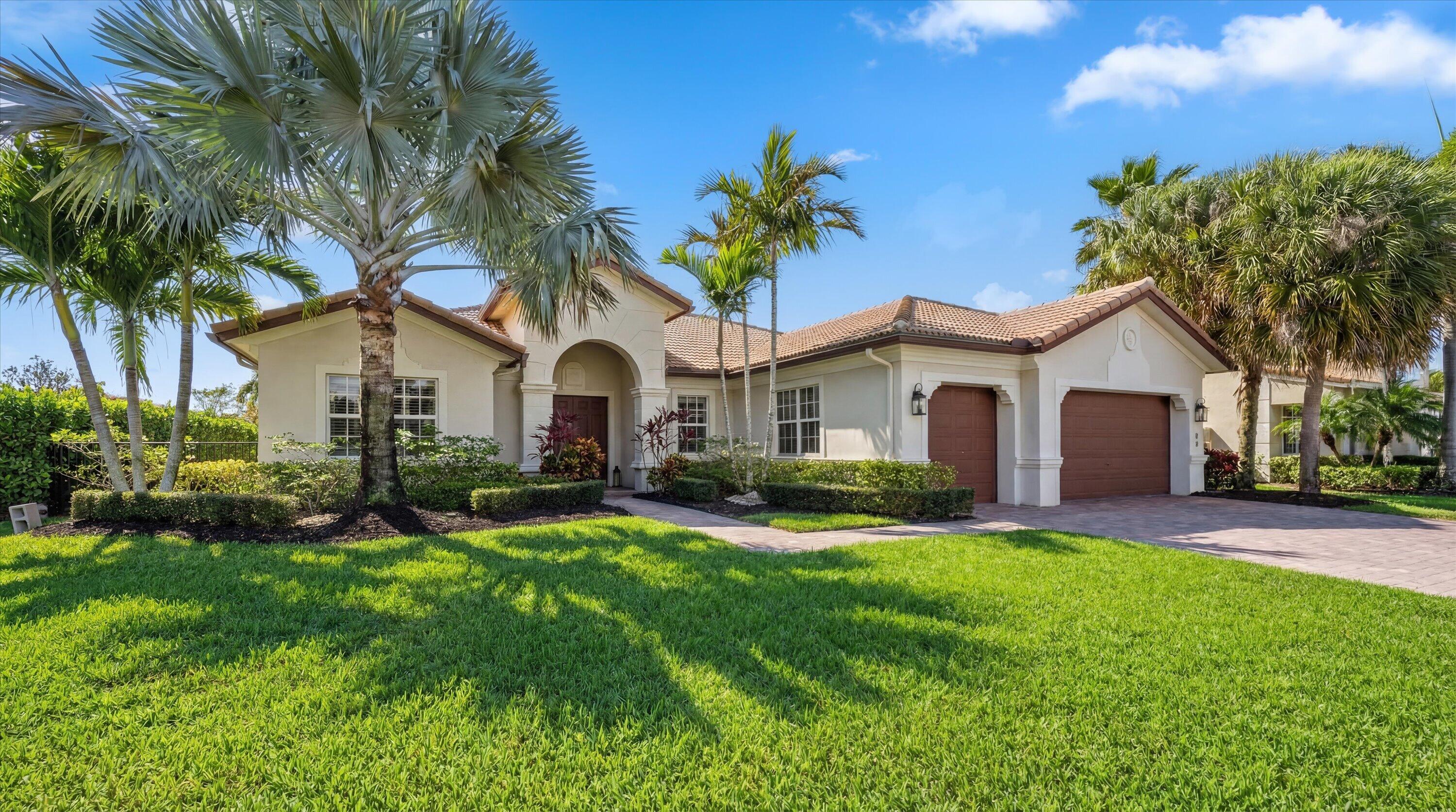 108 Casa Circle Jupiter, FL 33458 - Photo 1 of 53 a view of a white house with a big yard and potted plants