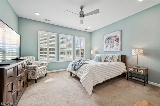 a spacious bedroom with a bed a couch and a window