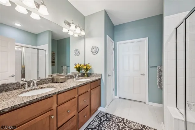 a spacious bathroom with a granite countertop double vanity and a mirror