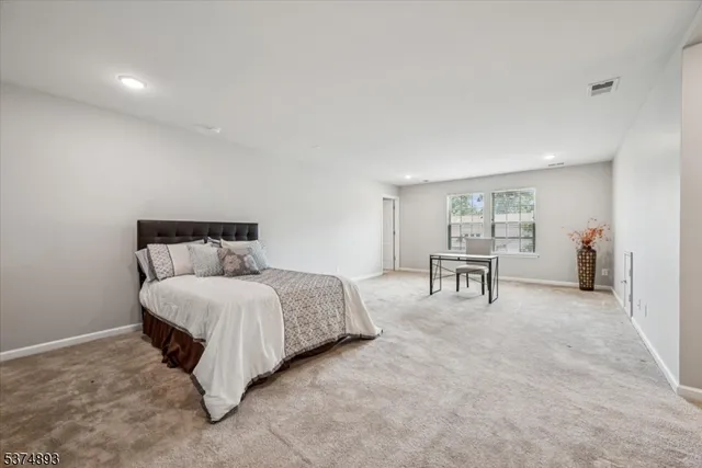 a spacious bedroom with a bed and a chair