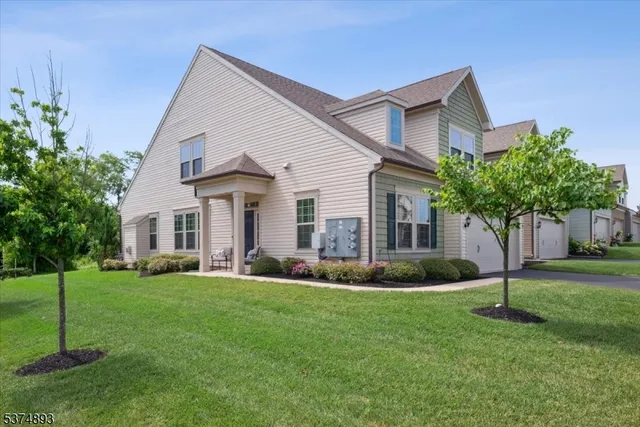 a front view of a house with a yard and trees