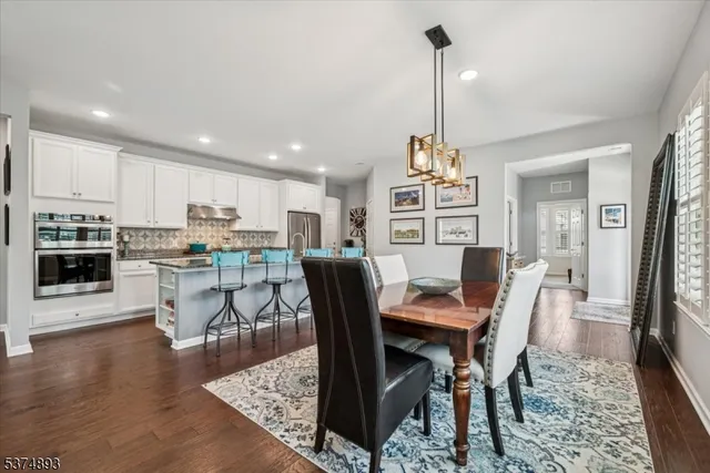a dining room with furniture a chandelier and wooden floor