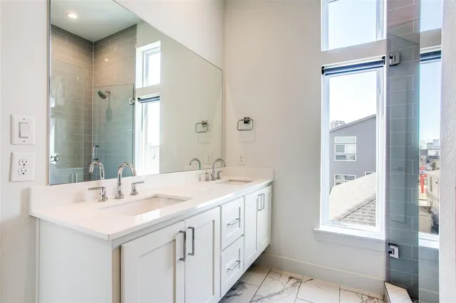 a bathroom with a sink a mirror and a shower