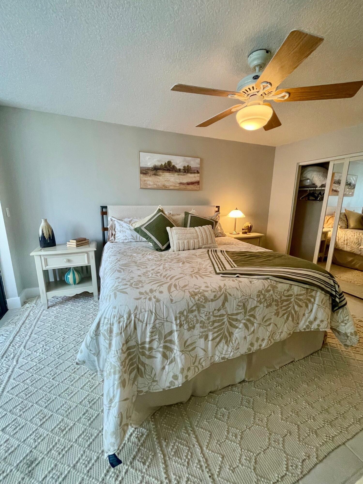 755 Dotterel Road, Unit 1312 Delray Beach, FL 33444 - Photo 12 of 21 a bedroom with a bed and a chandelier