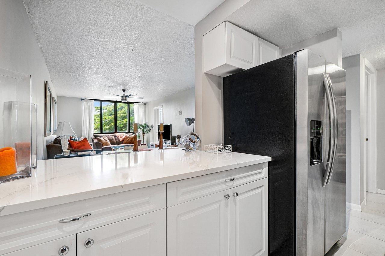 755 Dotterel Road, Unit 1312 Delray Beach, FL 33444 - Photo 8 of 21 a kitchen with stainless steel appliances a sink dishwasher and white cabinets next to a window