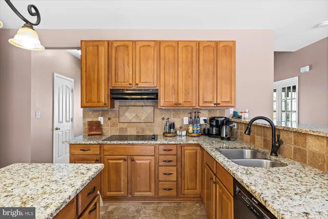 a kitchen with sink refrigerator dining table and chairs