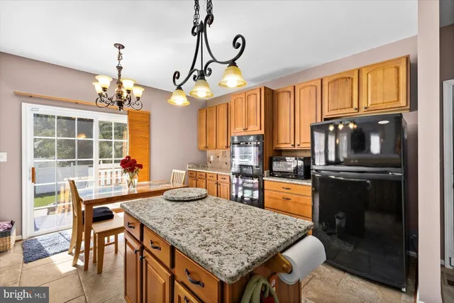 a kitchen with granite countertop a sink a stove and cabinets