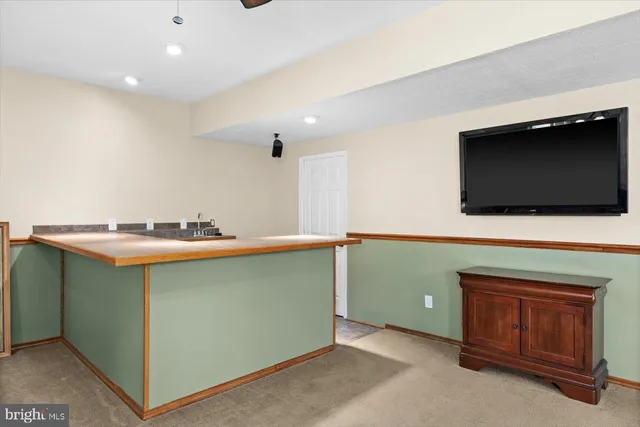 a room with pool table flat screen tv and windows