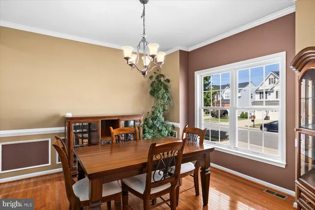 a dining room with furniture a chandelier and wooden floor