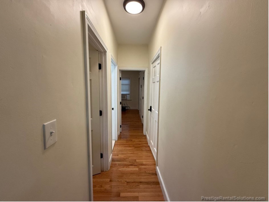 20 Pompeii Street, Unit 1 Boston, MA 02119 - Photo 2 of 7 a view of a hallway with wooden floor and a bathroom
