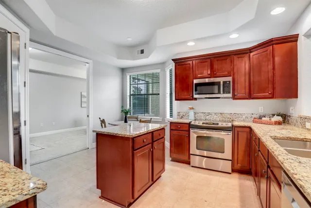 a bathroom with a granite countertop sink and a window
