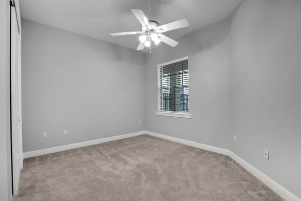 an empty room with a chandelier fan