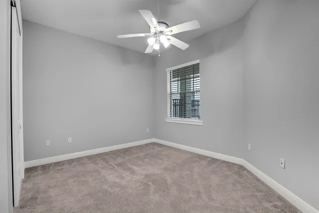 an empty room with a chandelier fan