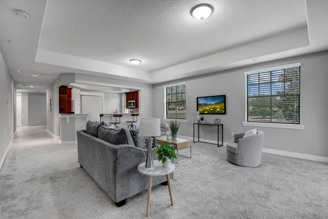 a bedroom with a large bed chandelier and a window