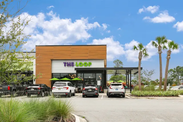 a front view of a house with a garden and a car parked