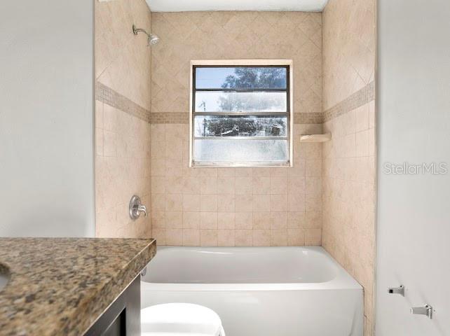5614 Riviera Drive Orlando, FL 32808 - Photo 11 of 15 a bathroom with a granite countertop bathtub sink and toilet