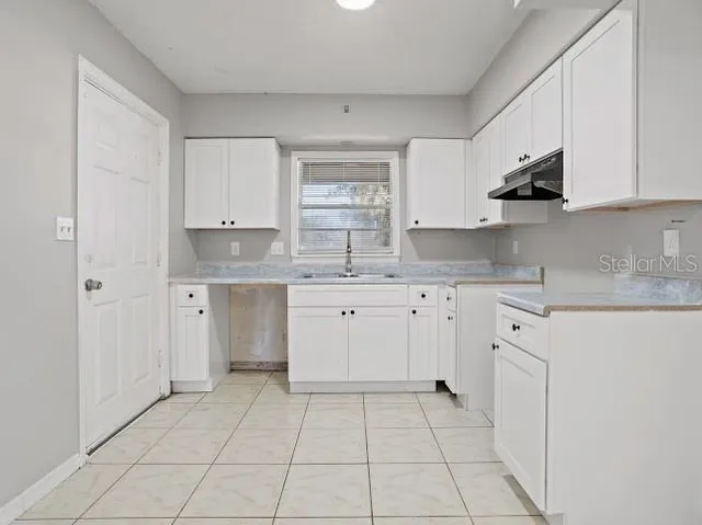a kitchen with a sink window and cabinets