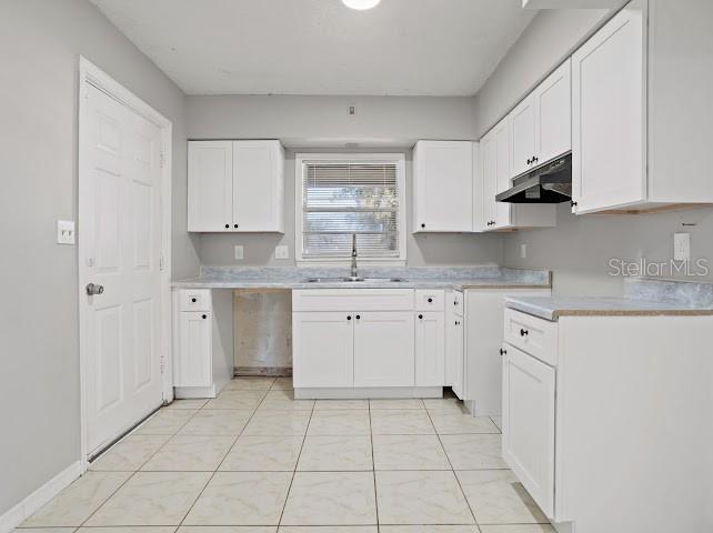 5614 Riviera Drive Orlando, FL 32808 - Photo 3 of 15 a kitchen with a sink window and cabinets