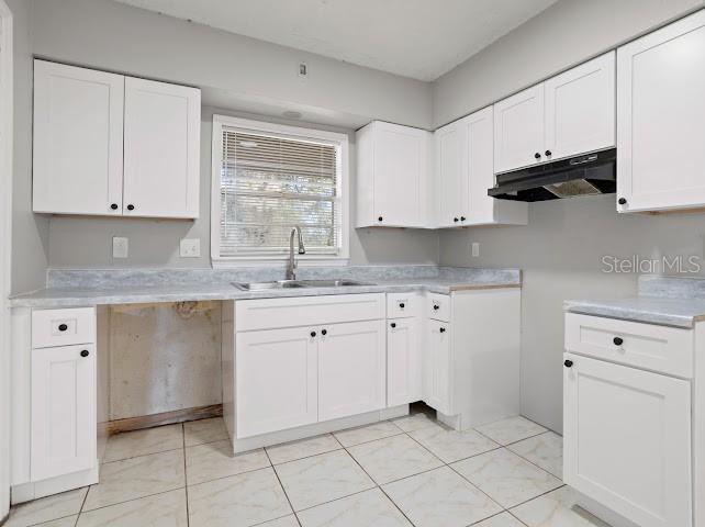5614 Riviera Drive Orlando, FL 32808 - Photo 4 of 15 a kitchen with granite countertop white cabinets white stainless steel appliances and sink