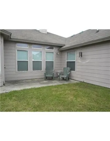 a backyard of a house with table and chairs