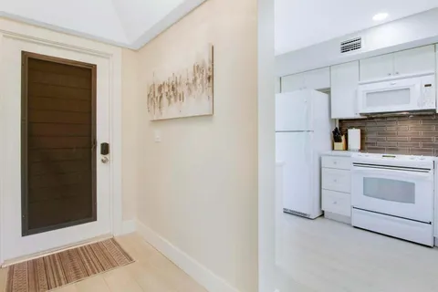 a kitchen with white cabinets and white appliances