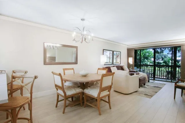 a view of a dining room with furniture a chandelier and wooden floor