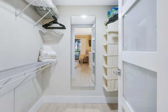 a view of walk in closet with clothes and shoes