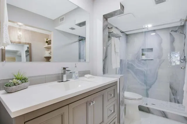 a bathroom with a sink a toilet and shower