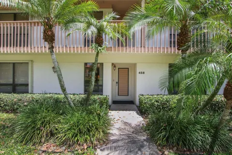 a front view of a house with plants