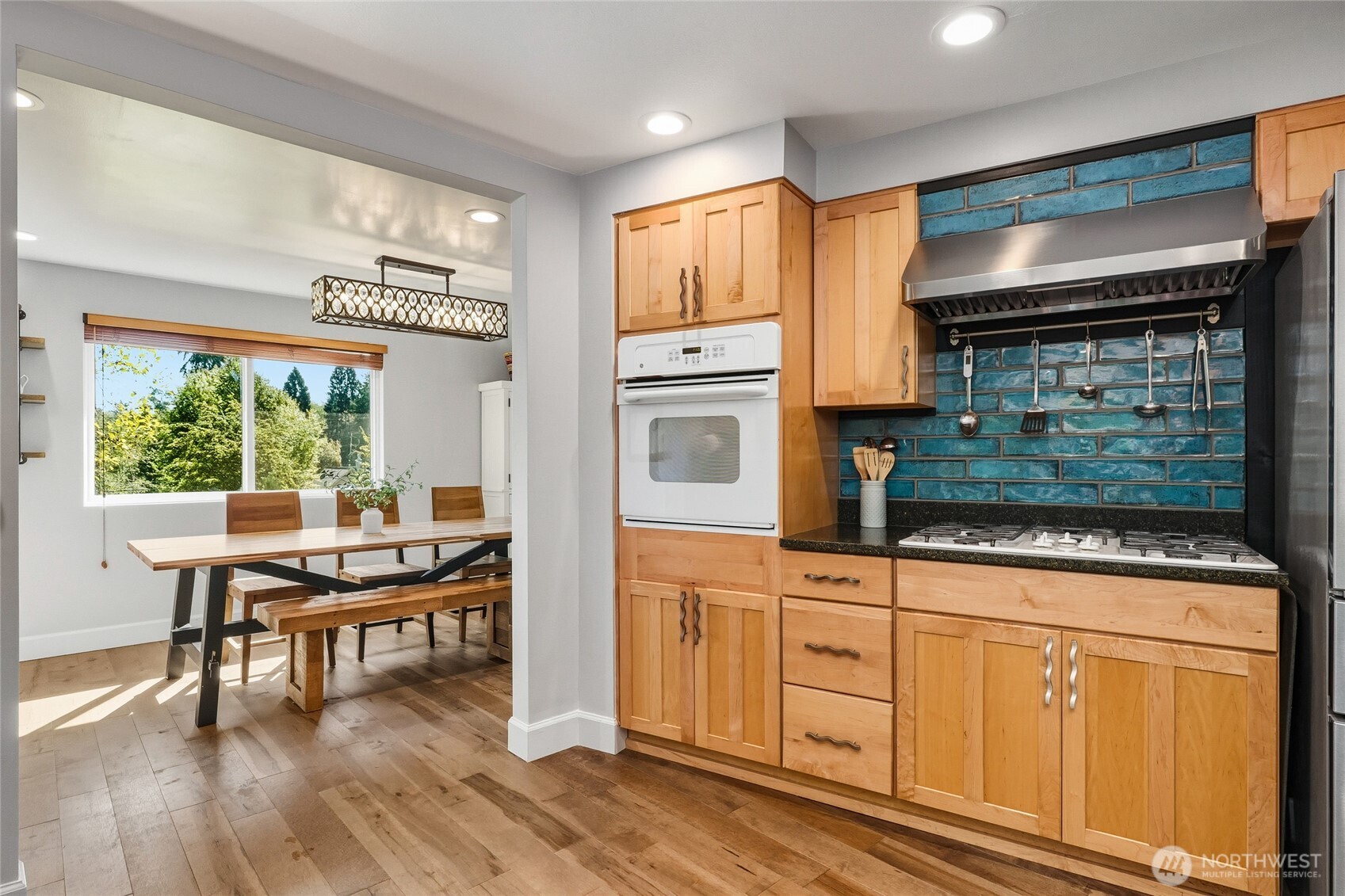 10414 Southwest 110th Street Vashon, WA 98070 - Photo 11 of 37 a kitchen with kitchen island granite countertop a stove and a wooden floors