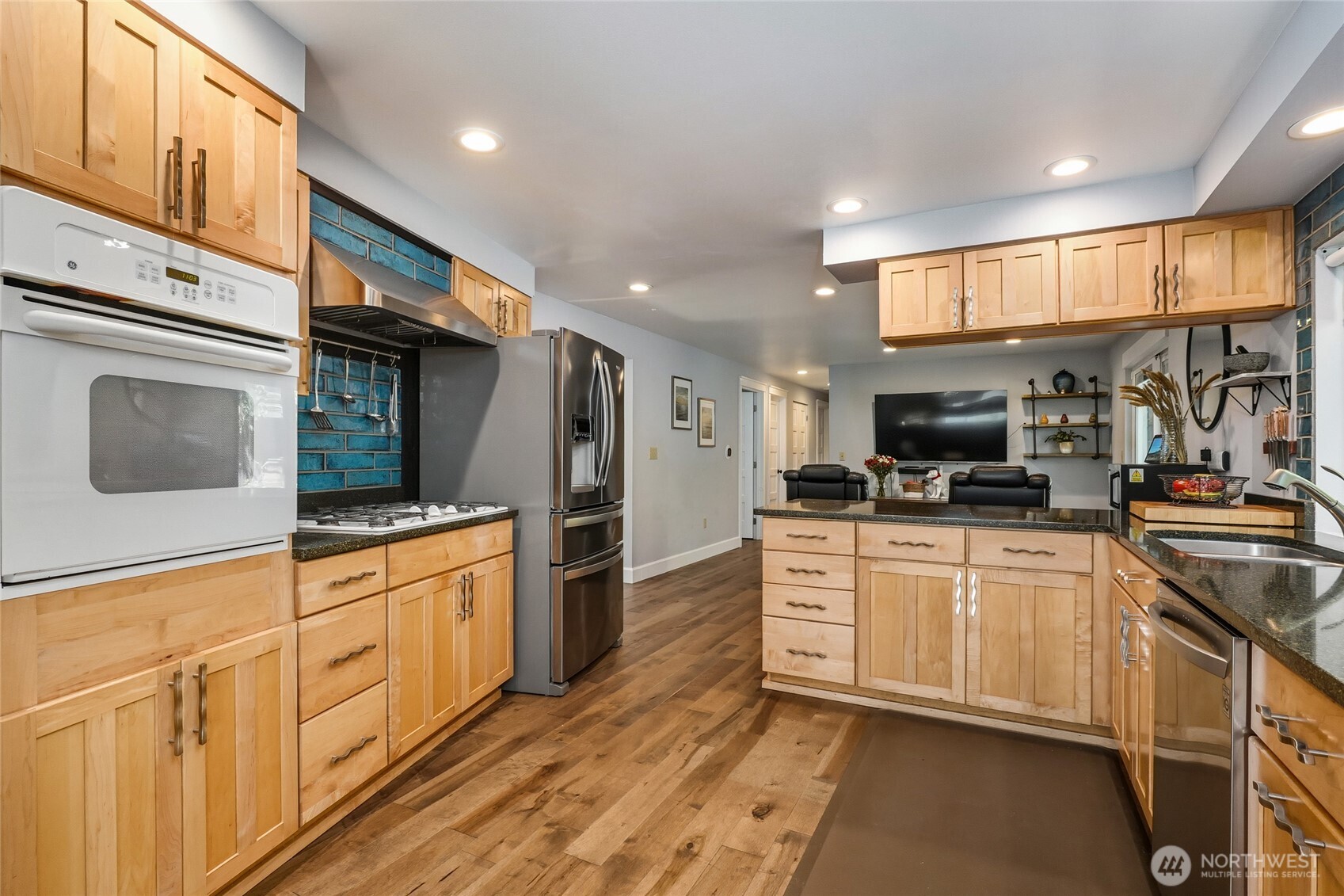 10414 Southwest 110th Street Vashon, WA 98070 - Photo 13 of 37 a kitchen with stainless steel appliances granite countertop a refrigerator a stove and a sink with wooden floors