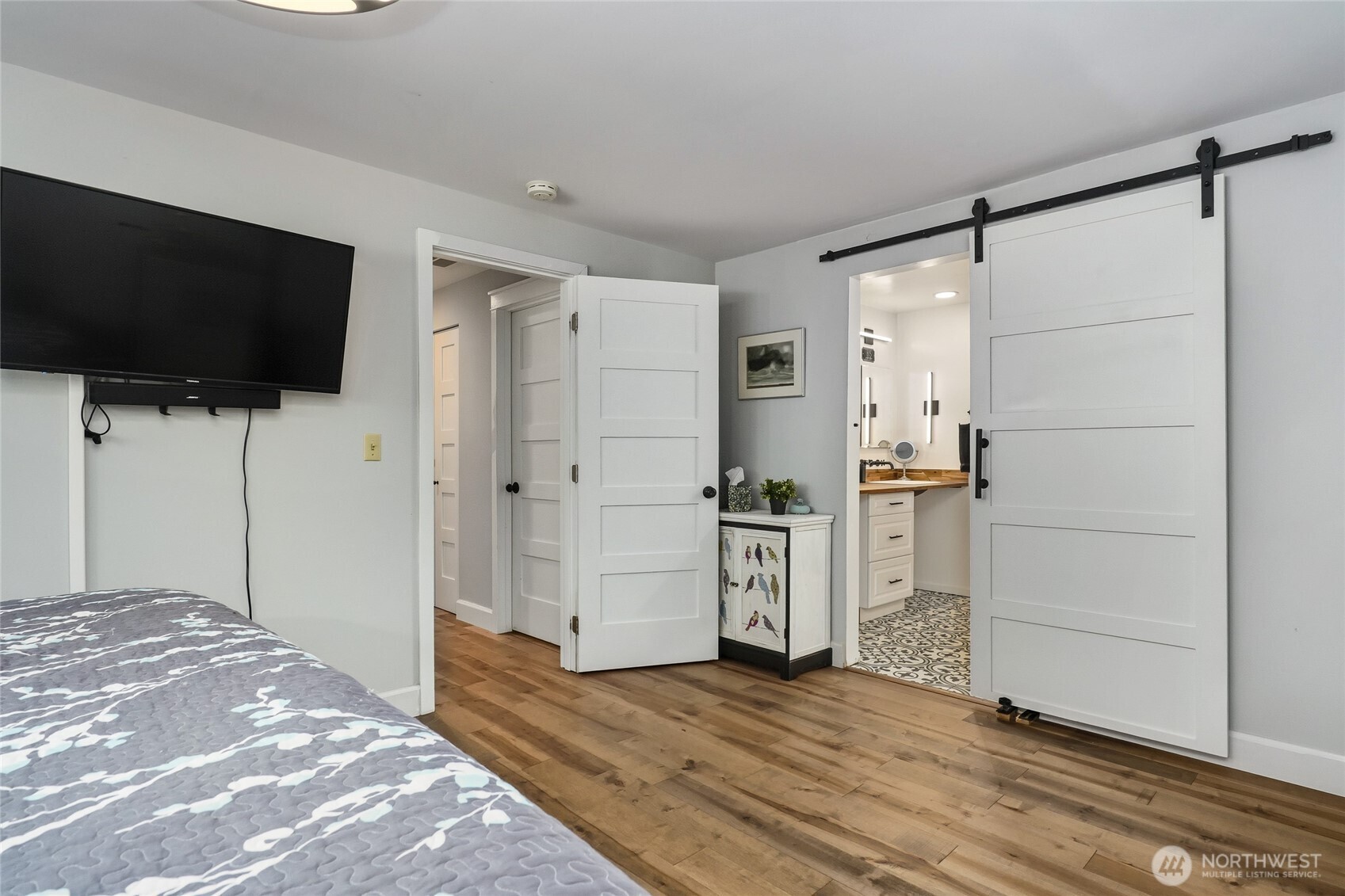 10414 Southwest 110th Street Vashon, WA 98070 - Photo 19 of 37 a view of a bedroom with wooden floor and flat screen tv