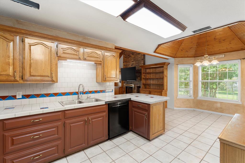 410 Etheridge Road Canton, TX 75103 - Photo 12 of 22 Kitchen with dishwasher, a sink, a peninsula, light tile patterned flooring, and tasteful backsplash