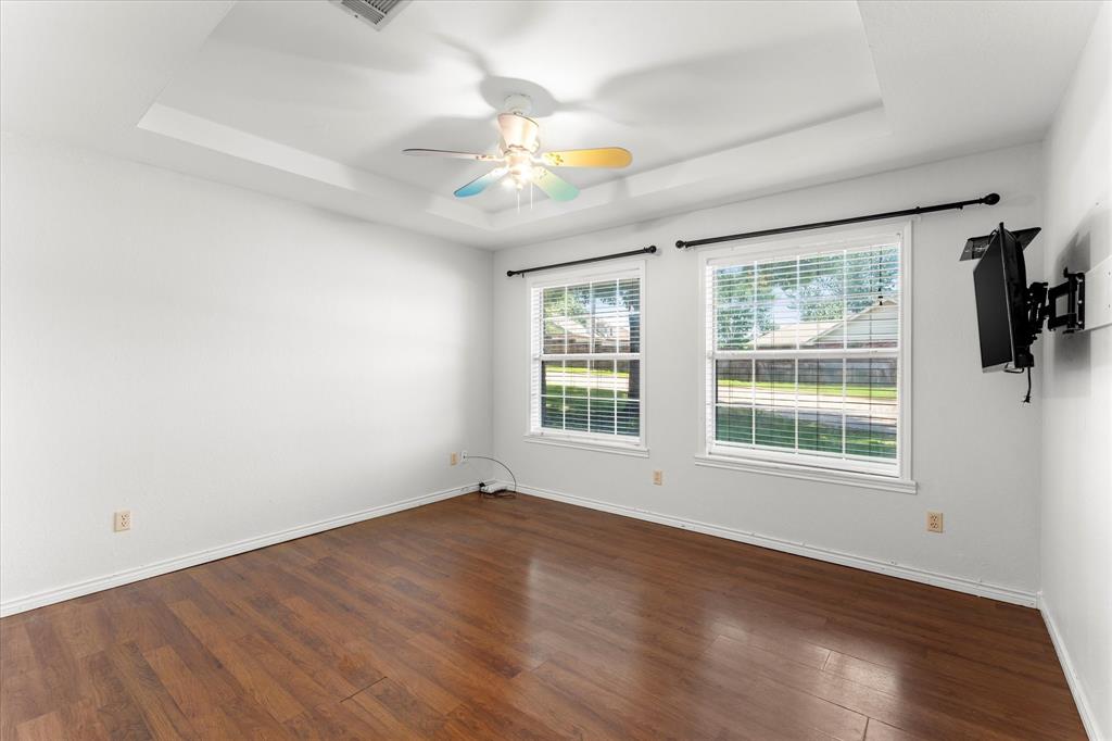 410 Etheridge Road Canton, TX 75103 - Photo 15 of 22 Spare room featuring a raised ceiling, wood finished floors, baseboards, and ceiling fan
