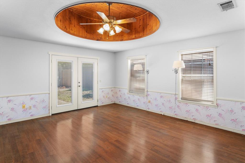 410 Etheridge Road Canton, TX 75103 - Photo 16 of 22 Spare room with french doors, wood finished floors, a tray ceiling, wallpapered walls, and a ceiling fan
