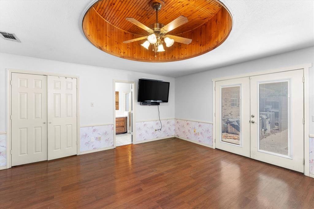 410 Etheridge Road Canton, TX 75103 - Photo 17 of 22 Unfurnished bedroom featuring french doors, a tray ceiling, wood finished floors, access to outside, and baseboards