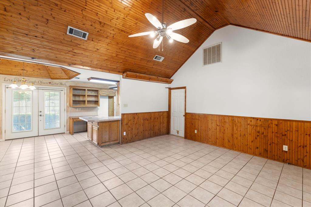 410 Etheridge Road Canton, TX 75103 - Photo 8 of 22 Unfurnished living room featuring wainscoting, wood walls, lofted ceiling, ceiling fan, and wood ceiling