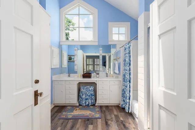 a white kitchen with a stove a refrigerator and a window