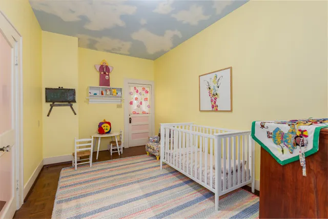 a bedroom with baby bed and a window