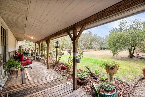 a view of a living room and floor to ceiling window or wooden deck