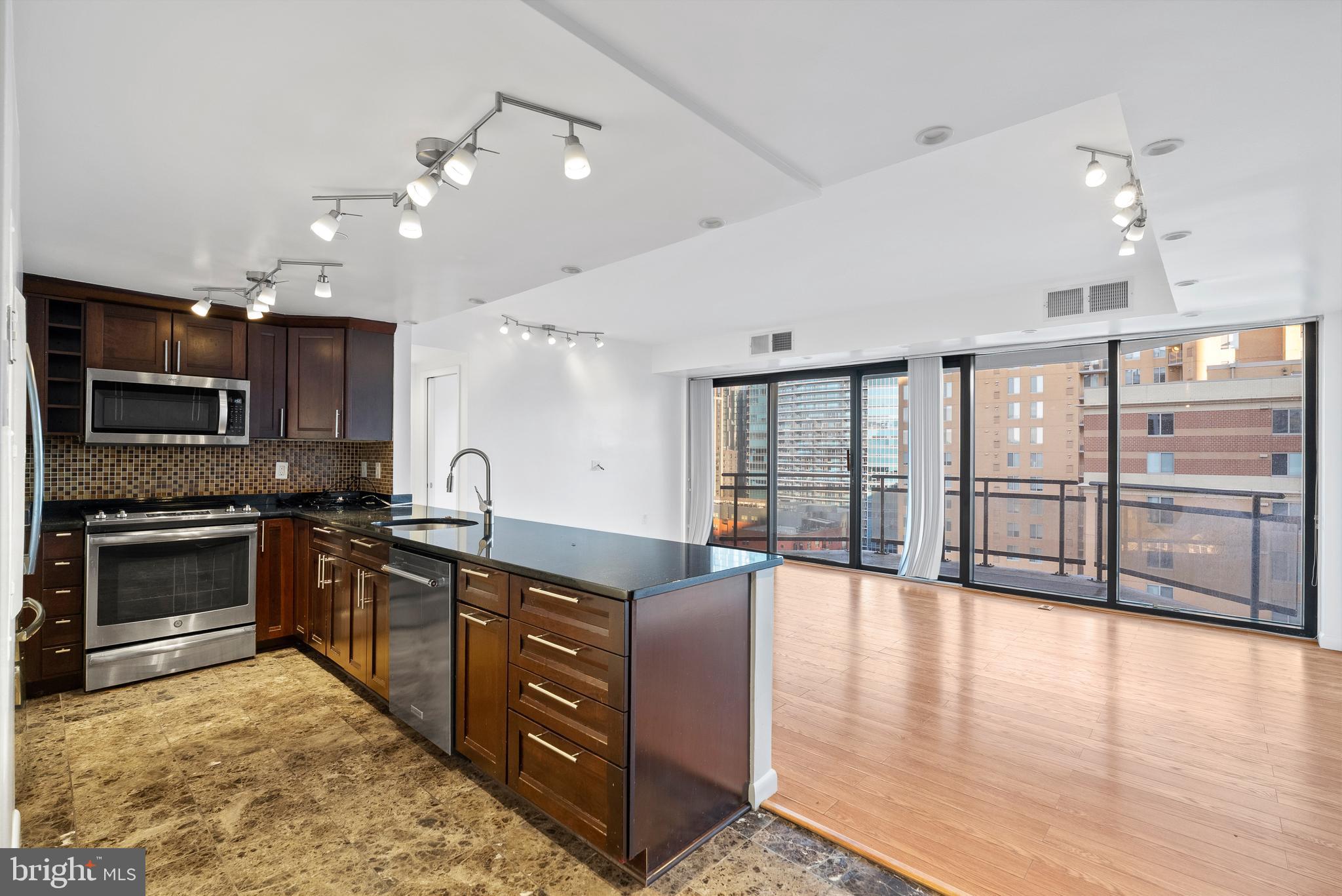 1530 Key Boulevard, Unit 930 Arlington, VA 22209 - Photo 2 of 20 a large kitchen with stainless steel appliances granite countertop a stove and cabinets with wooden floor