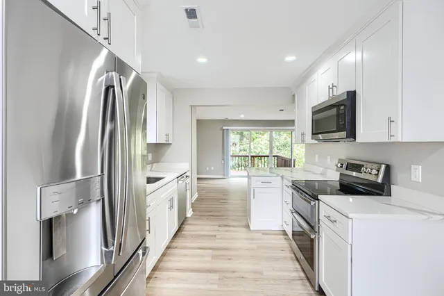 a kitchen with stainless steel appliances a stove a sink and a refrigerator