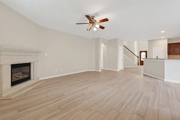 a view of a livingroom with wooden floor and a ceiling fan