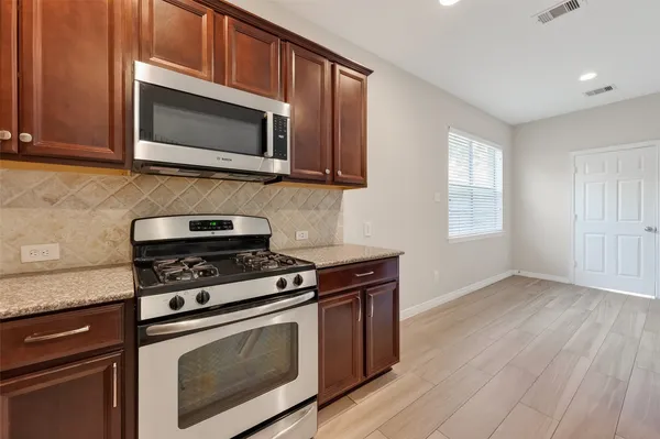 a kitchen with stainless steel appliances granite countertop a stove microwave and oven