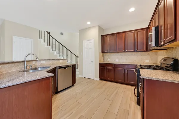 a kitchen with a sink a stove a microwave and wooden cabinets
