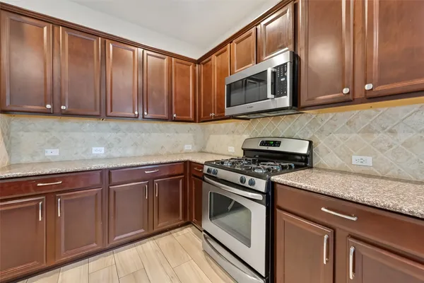 a kitchen with granite countertop cabinets stainless steel appliances and wooden cabinets