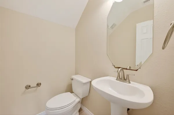 a bathroom with a sink a toilet and mirror