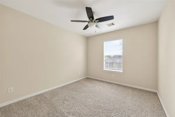 an empty room with a window and a fan